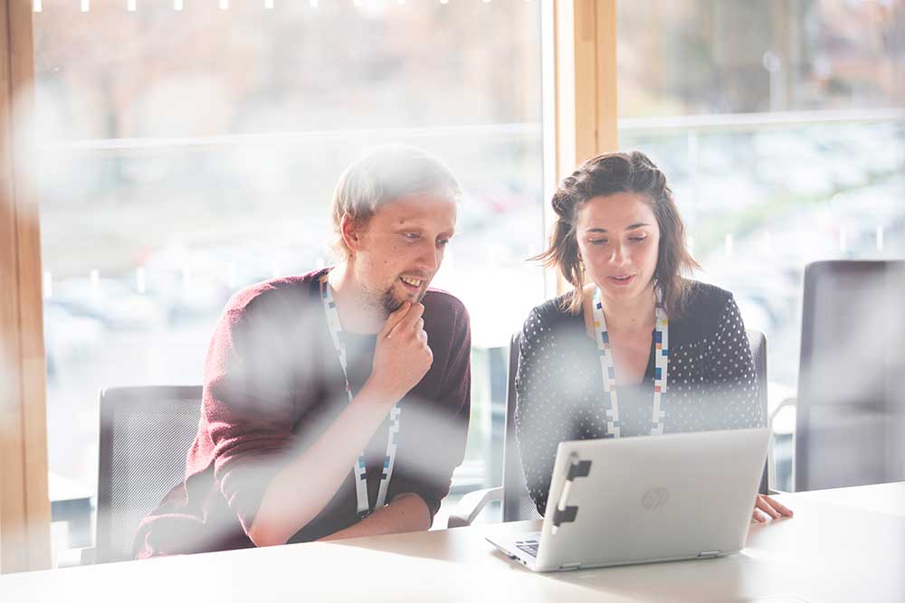 2 UKHO employees looking at laptop