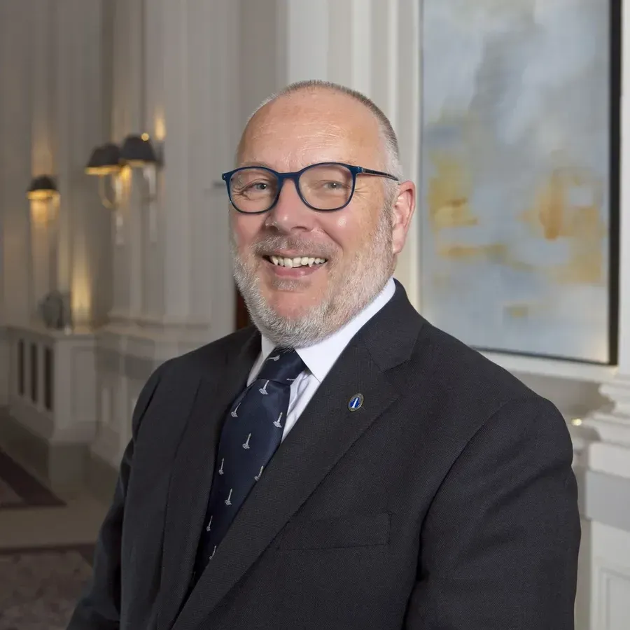 Man in a black suit smiling