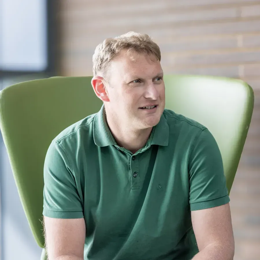Man wearing a green tshirt sitting in a green chair