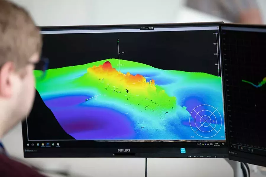 UKHO staff looking at seabed data on a computer