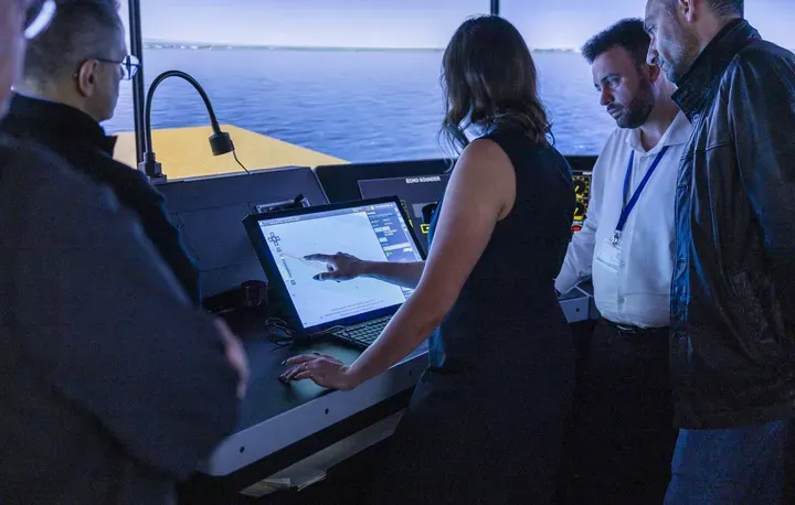 Four people looking at an S-100 ECDIS