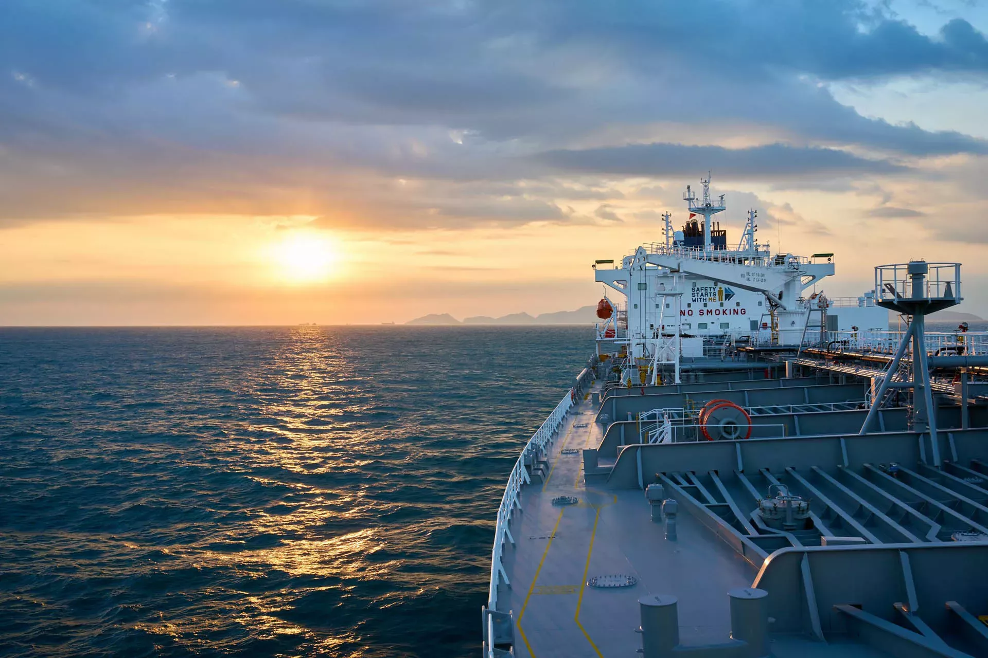 Ship's bow facing the sunset on the horizon