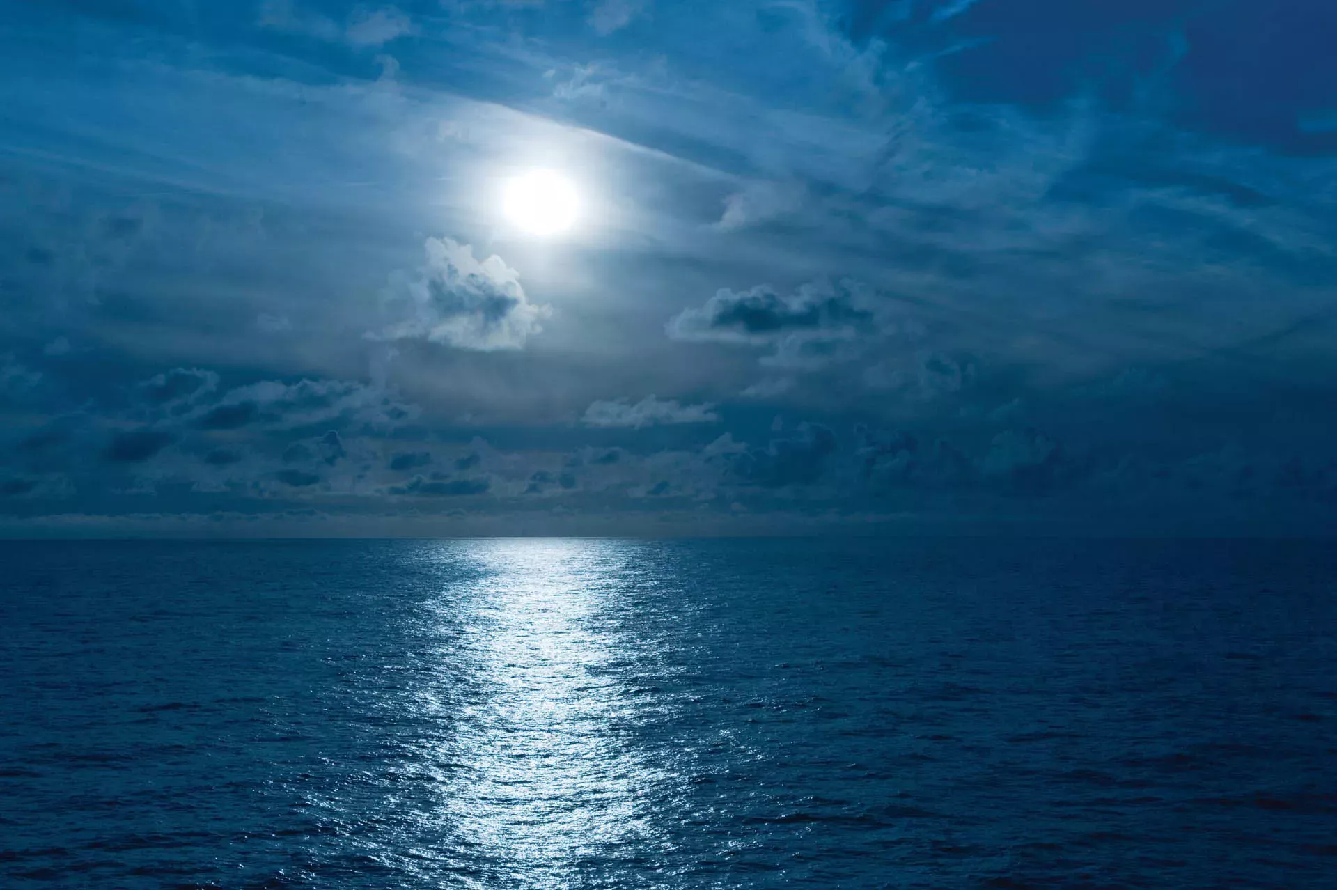 Moon casting reflection over the ocean at night