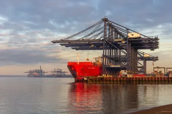 Red ship being loaded at a port