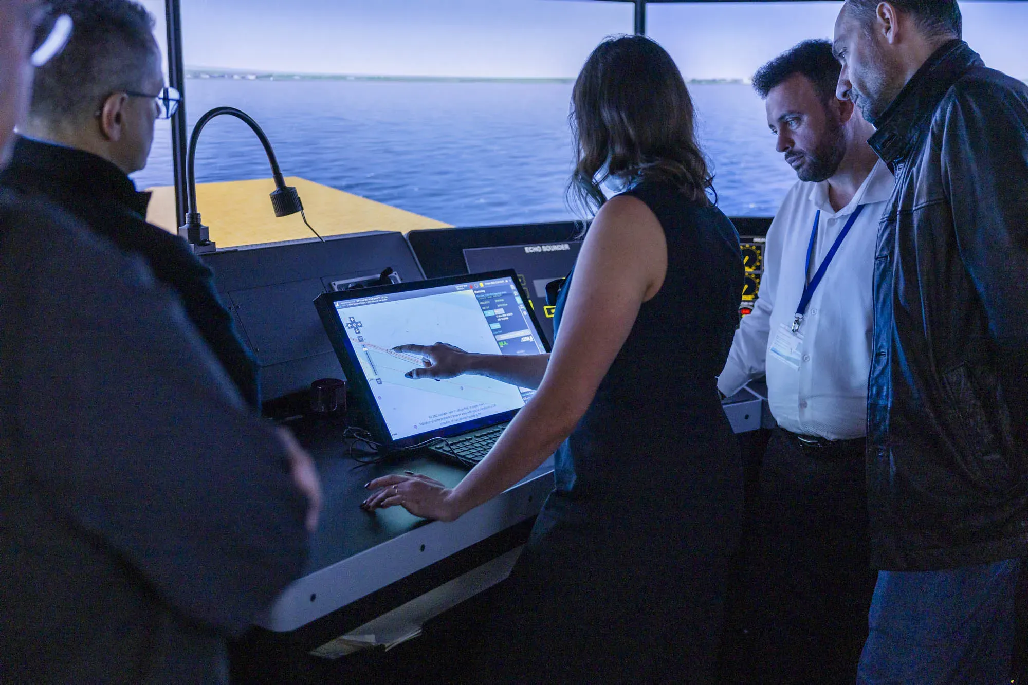 Four people looking at an S-100 ECDIS